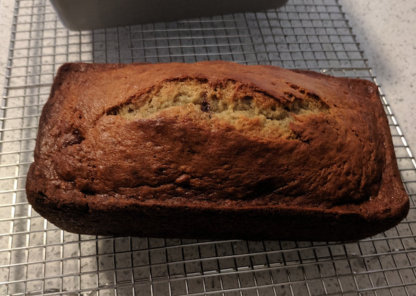 Loaf of banana bread with chocolate chips on a cooling rack